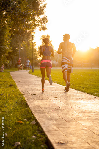 Young couple running at sunset in park