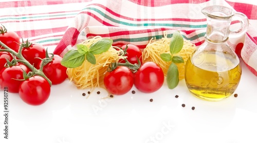 Photo of tagliatelle with cherry tomatoes,basil,oil,garlic at the top on white