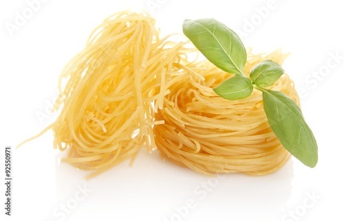 Closeup shot of tagliatelle with basil isolated on white