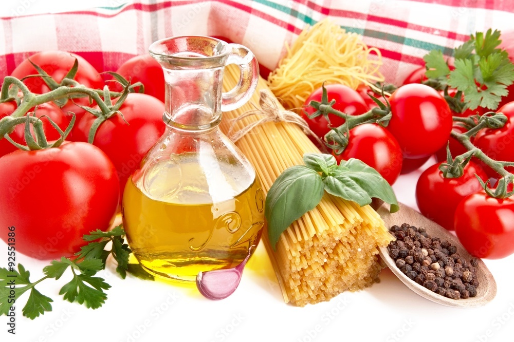 Photo of pasta with tomatoes,basil,oil,garlic at the top on white