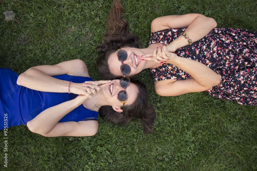 Naklejka premium Two intimate cute girls, relaxing in grass. Made 
