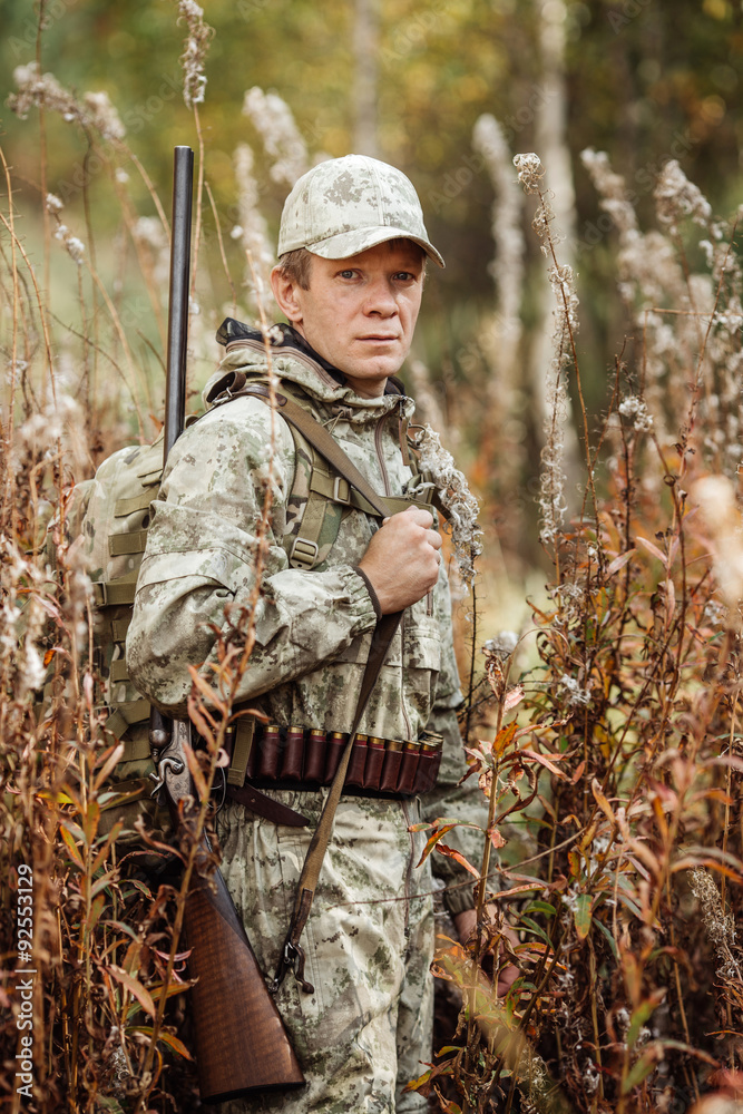 man hunter with shotgun in forest