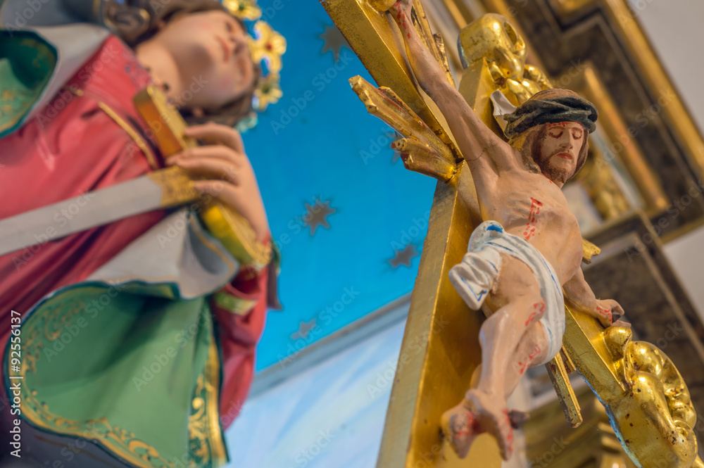 Crucifix with Jesus Christ and a female saint in the background,