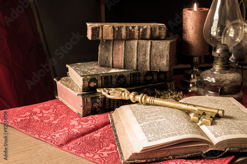 Artistic vintage big key with old books photo