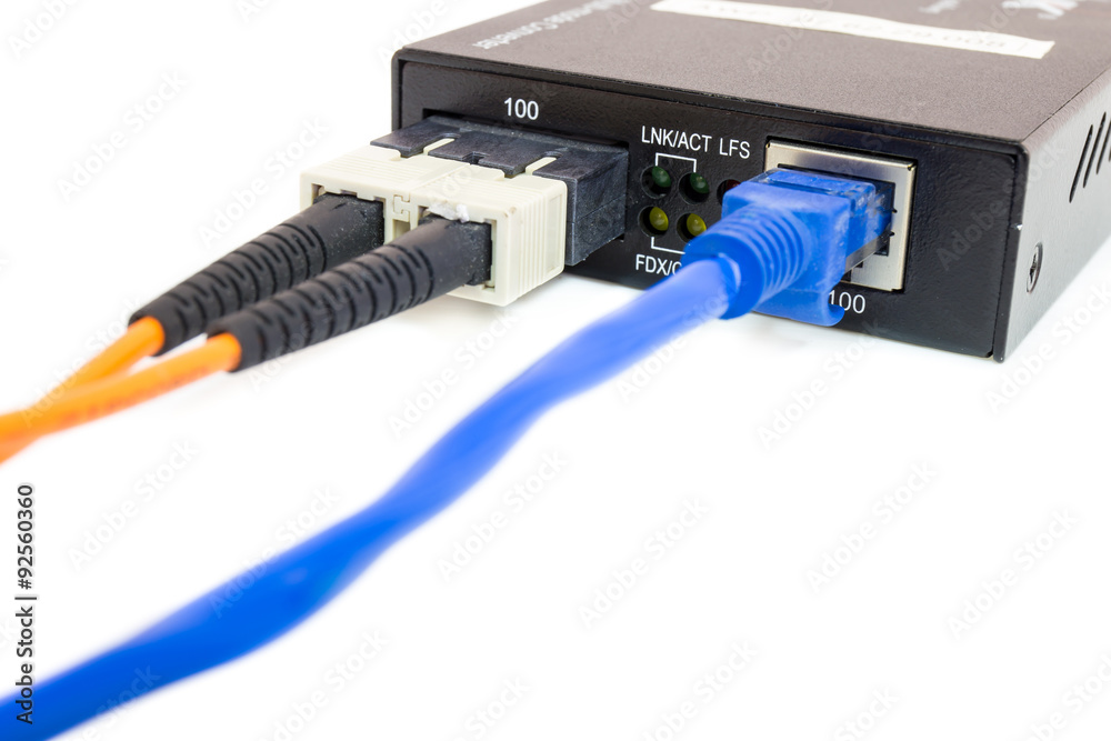 Close up fiber media converter and cables on white isolated background Close up fiber media converter and cables on white isolated background