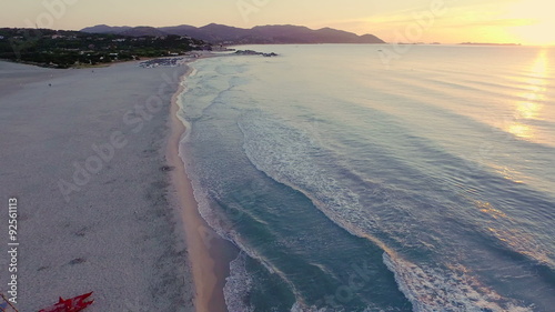 AERIAL: flying over desert beach at sunrise