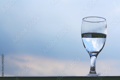 Drink a glass of water on a rainy day with the sky background.