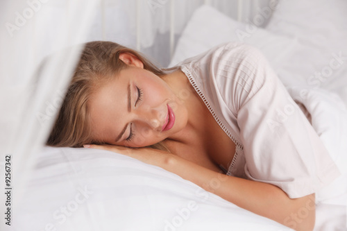 Beautiful woman sleeping in the bed with closed eyes