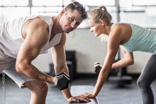  Couple exercising with dumbbells in gym