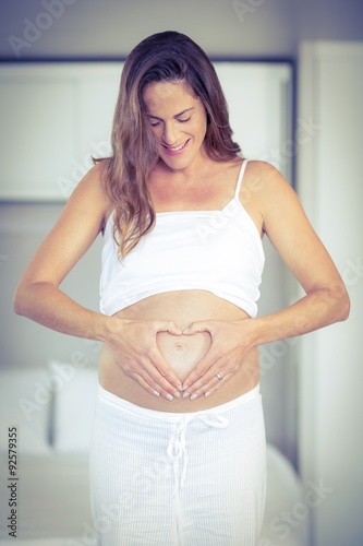 Happy woman making heart on belly Free Download Happy woman making heart on belly - GFXLoad