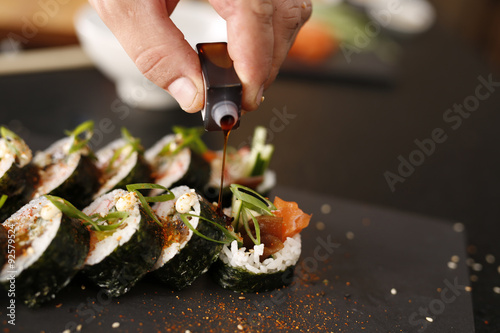 Sushi. Klasyczne grube rolki futomaki podane na kamiennym talerzu