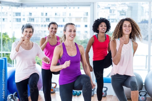 Portrait of smiling women exercising with clasped hands 