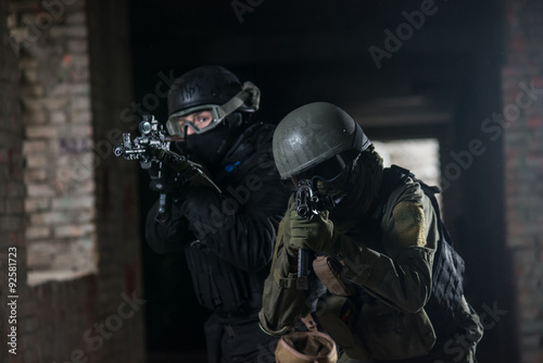 Fully equipped military men with automatic weapons playing