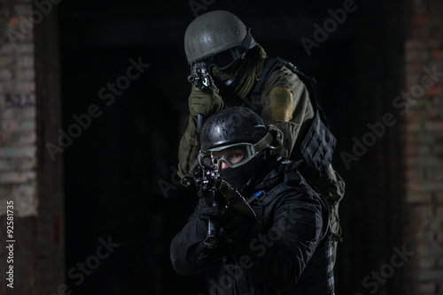 Fully equipped military men with automatic weapons playing