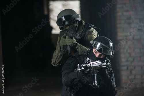 Fully equipped military men with automatic weapons playing