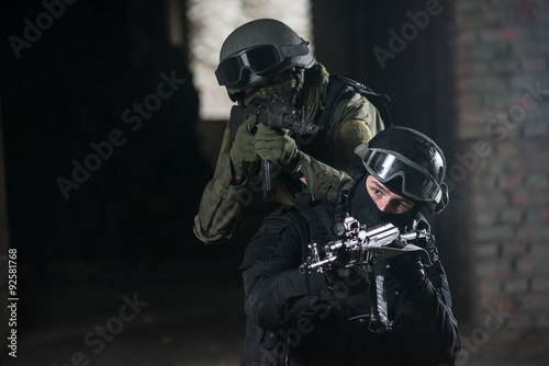 Fully equipped military men with automatic weapons playing