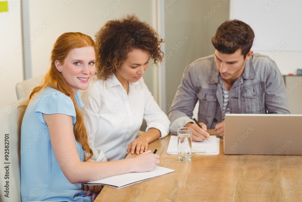 Smiling businesswoman with colleagues in meeting Smiling businesswoman with colleagues in meeting