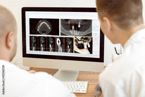 Dentists and assistant discussing the x-ray