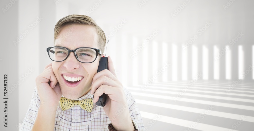 Composite image of geeky hipster holding a retro cellphone Composite image of geeky hipster holding a retro cellphone