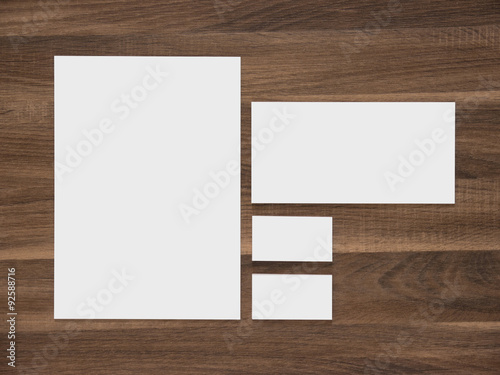 Blank paper, envelope and business cards on wooden background.