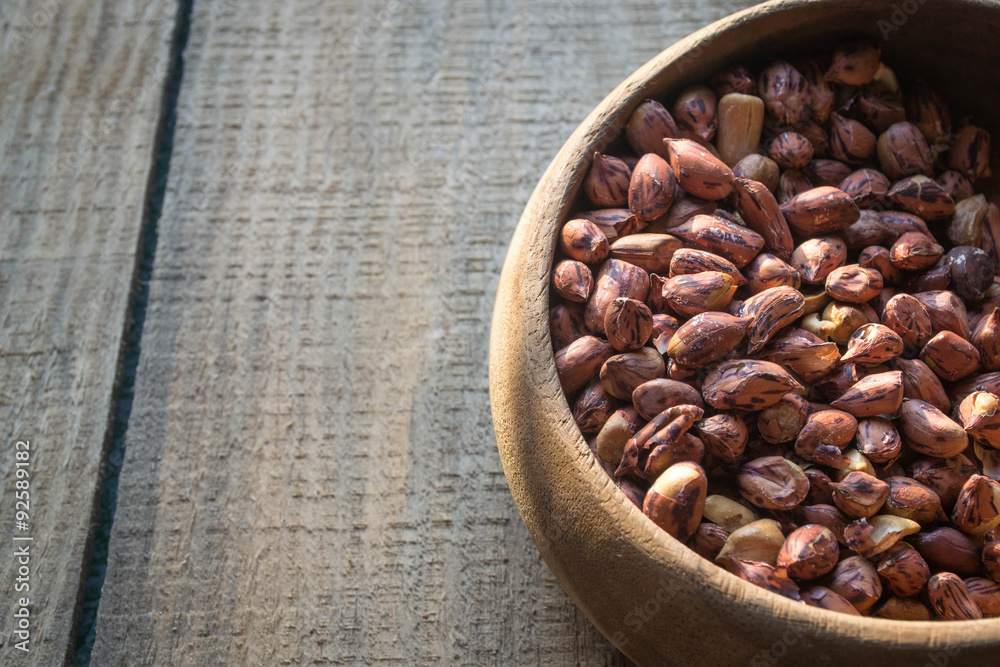 Fototapeta premium peanuts or groundnuts in wooden bowl