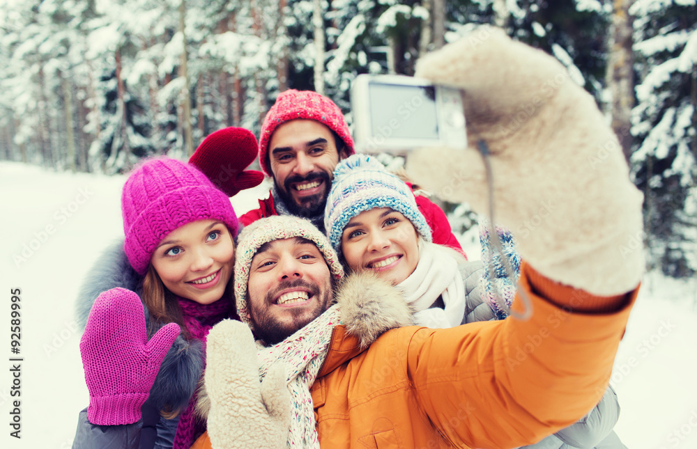 smiling friends with camera in winter forest smiling friends with camera in winter forest