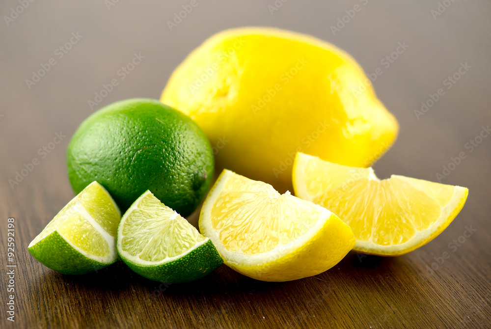 Macro closeup of lime and lemon wedges with whole fruits behind Macro closeup of lime and lemon wedges with whole fruits behind