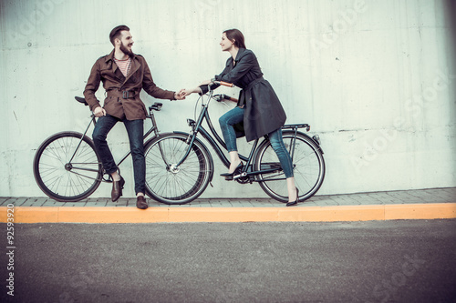 Fototapeta Naklejka Na Ścianę i Meble -  Young couple with a bicycle opposite city 
