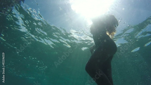 Wallpaper Mural Woman in Bikini swimming underwater towards surface with beautiful sun flares. Instagram Color Tone Torontodigital.ca