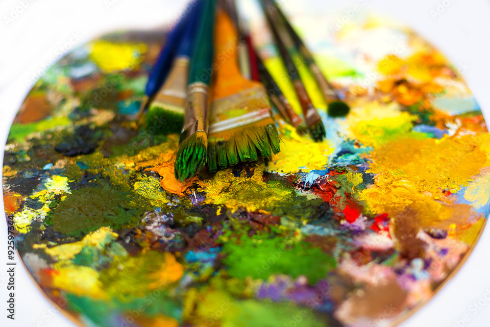 Paint brushes to the painting palette with colors  