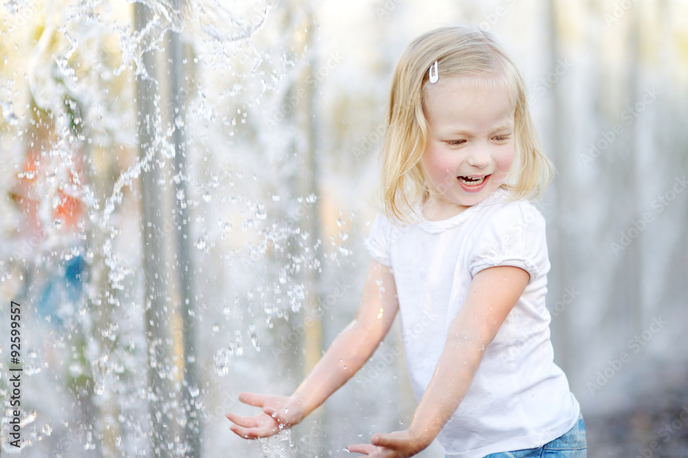 Cute little girl playing with a city fountain Cute little girl playing with a city fountain