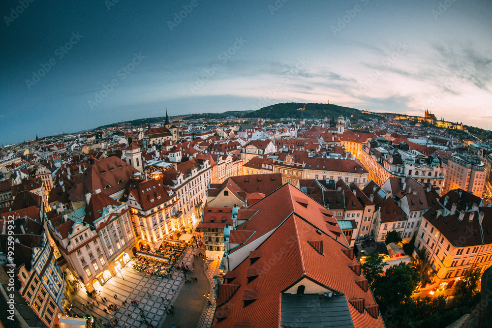 Red roofs of Prague during a beautiful sunset with the lights of lanterns