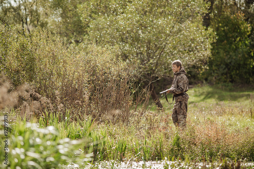 hunter in camouflage clothes ready to hunt with hunting rifle