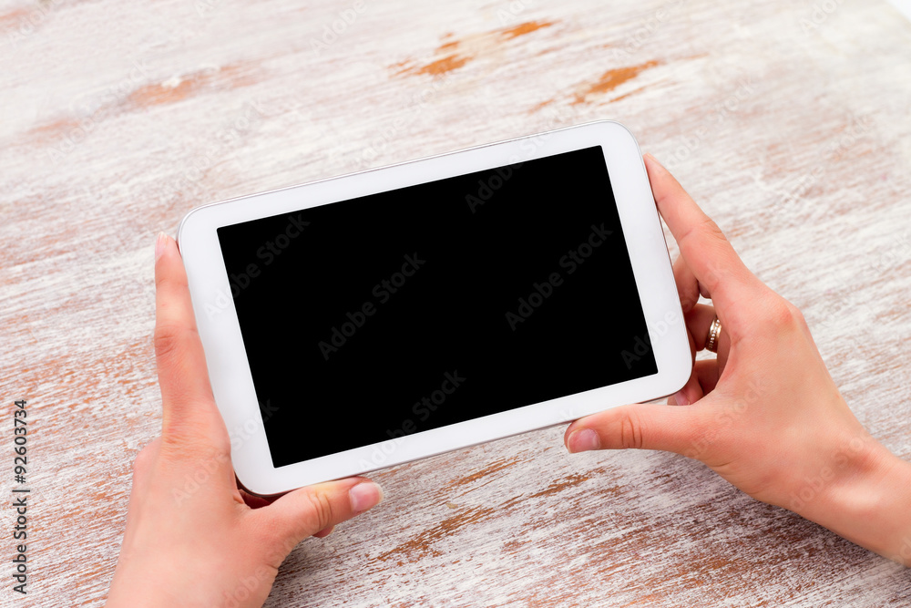Tablet computer in woman hands over table