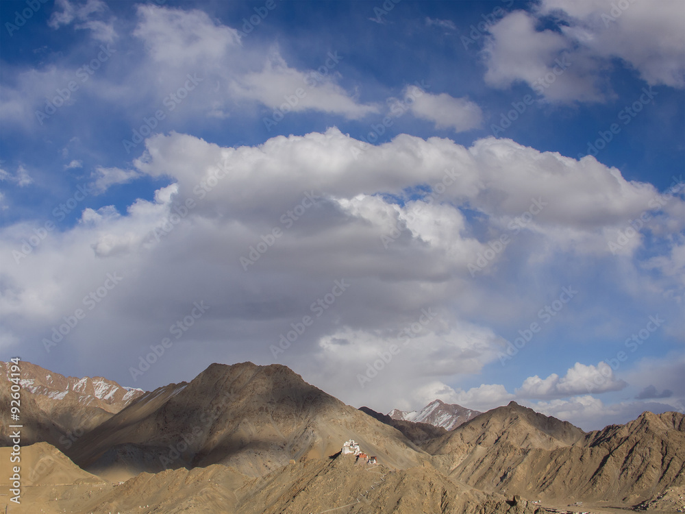  Brown  mountains and 80 percent of area of blue sky and some cl