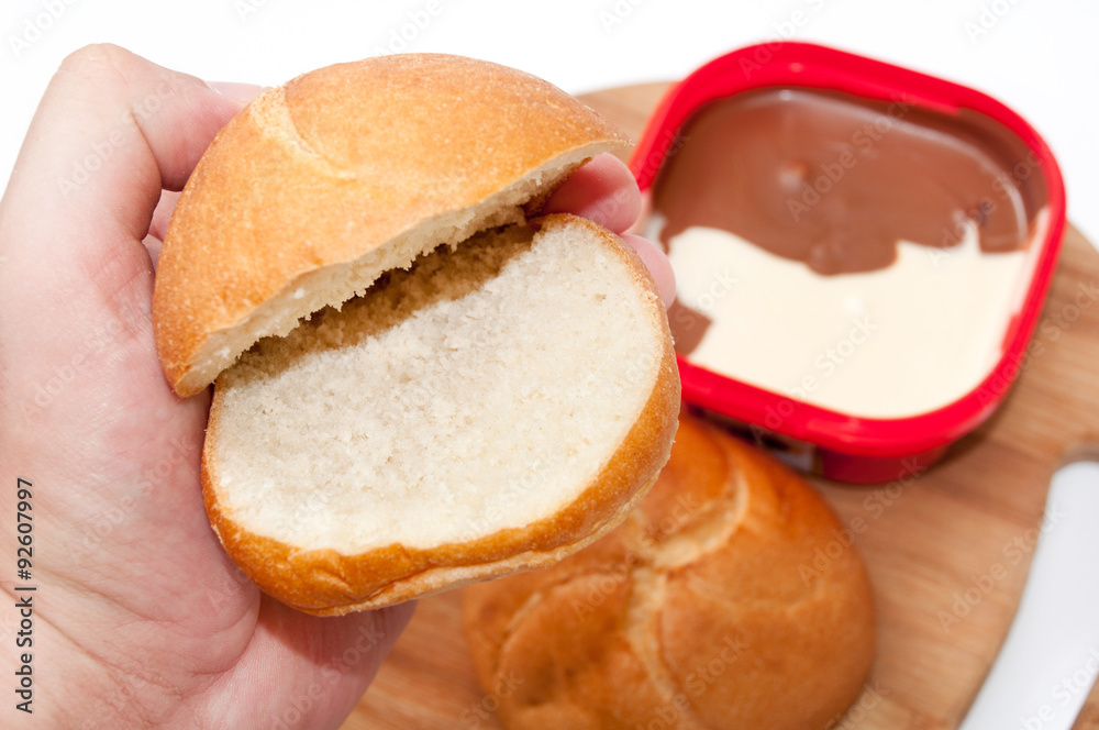 Hand holding donut for topping with chocolate cream Hand holding donut for topping with chocolate cream