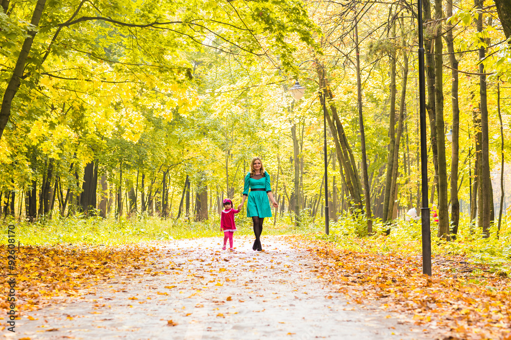 Fototapeta premium happy mother with her daughter for a walk in autumn park