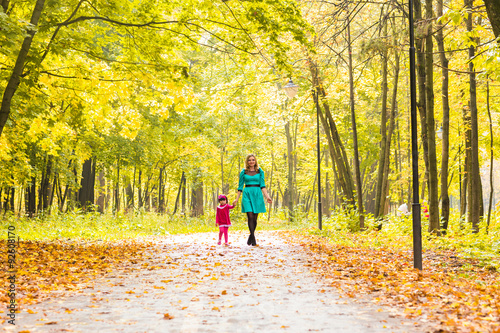 happy mother with her daughter for a walk in autumn park