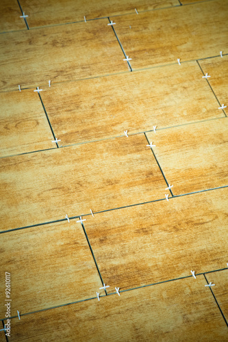 Laying ceramic tiles on a special cement grout. Selective focus.