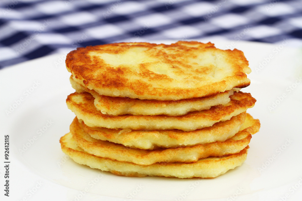 Potato fritters stacked up on white plate
Potato fritters stacked up on white plate