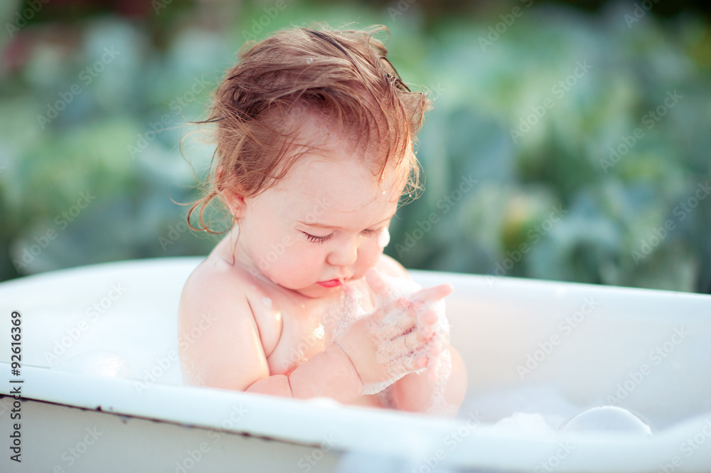 Baby having bath outdoors. Playful. Washing time. Childhood. Baby having bath outdoors. Playful. Washing time. Childhood.