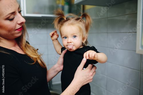 Mother with daughter standing in kitchen