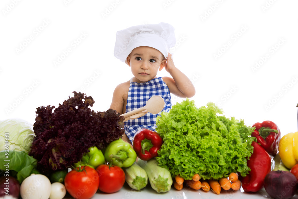 Little boy in chef's hat with scoop and cooking vegetables Little boy in chef's hat with scoop and cooking vegetables