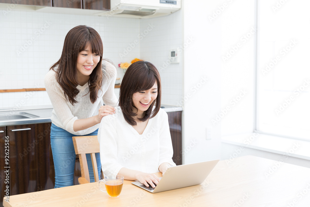 asian women using laptop in the kitchen