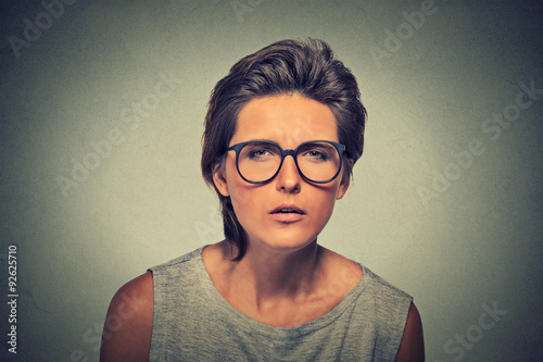 Displeased unsure arguable suspicious thinking young lady in glasses photo