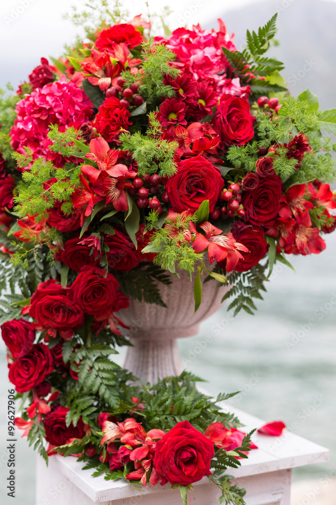 flower arrangement in stone bowl with red roses