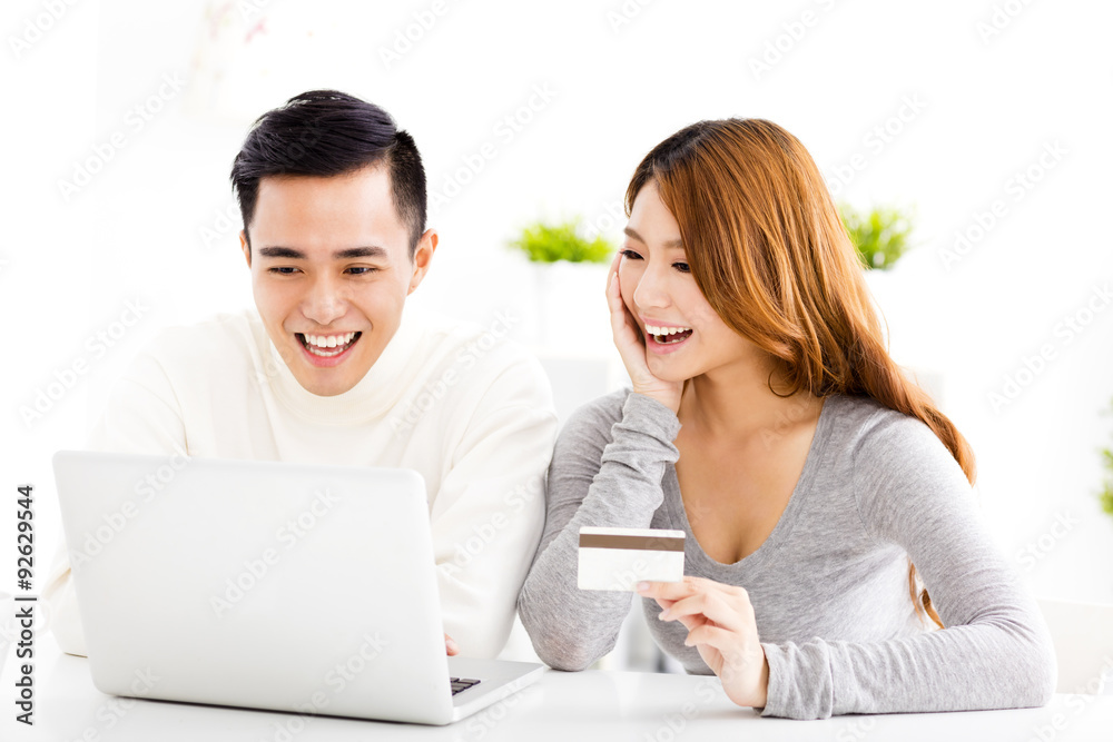 happy young couple with credit card and laptop happy young couple with credit card and laptop