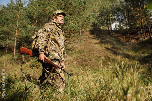hunter in camouflage clothes ready to hunt with hunting rifle