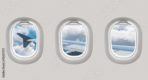 Looking out the windows of a plane to the aircraft wing and clou photo