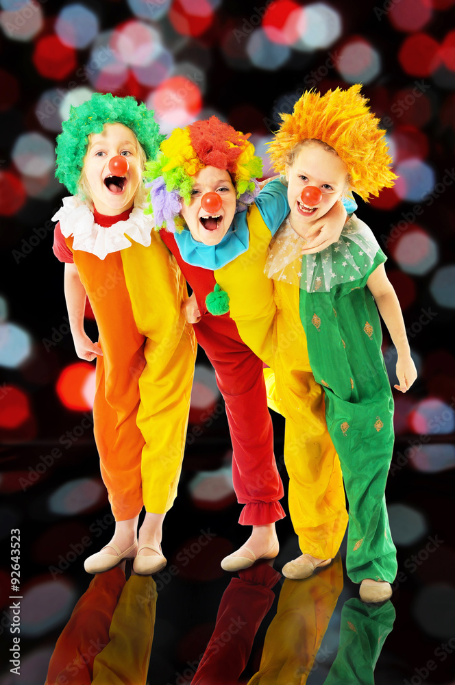  Group of happy children dressed up as colorful funny clowns
